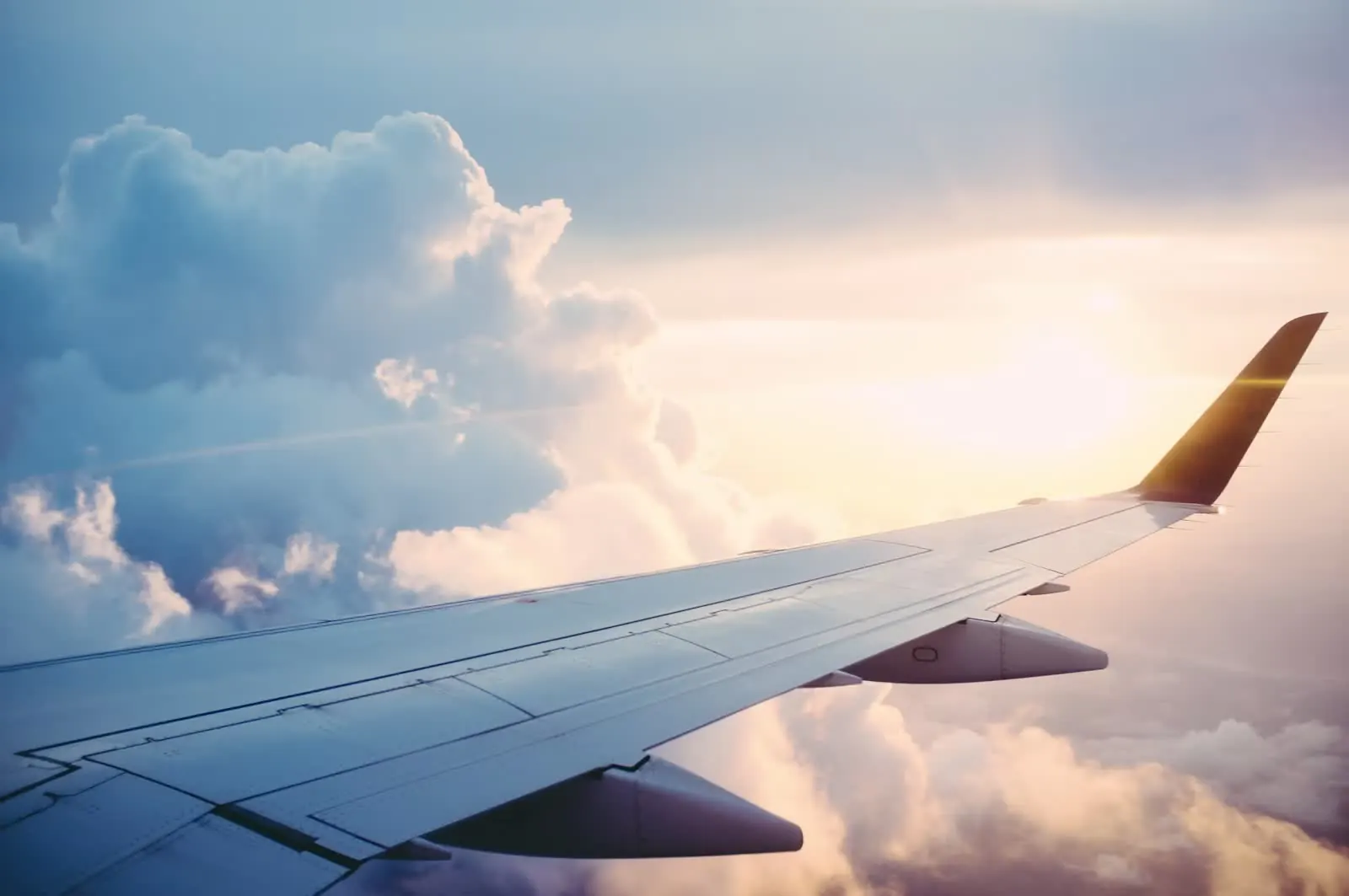 Airplane wing view from window at sunset